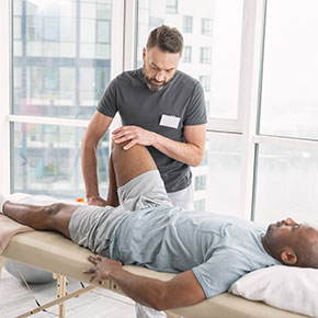 Picture of a male Occupational Therapist and a male Patient. The patient is lying down relaxing snd therapistThe occupational therapist will provide assistance to patients by contributing to their ability to perform their life roles in the occupations of work, self-care, and leisure. The entire staff of therapists, assistants, aides, and clerical personnel is committed to excellence in all areas of rehabilitation.